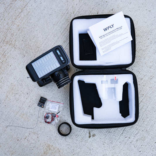 WFLY X9S 9-channel 2.4GHz radio transmitter set with RG209S receiver, instruction manual, and accessories in protective foam case.