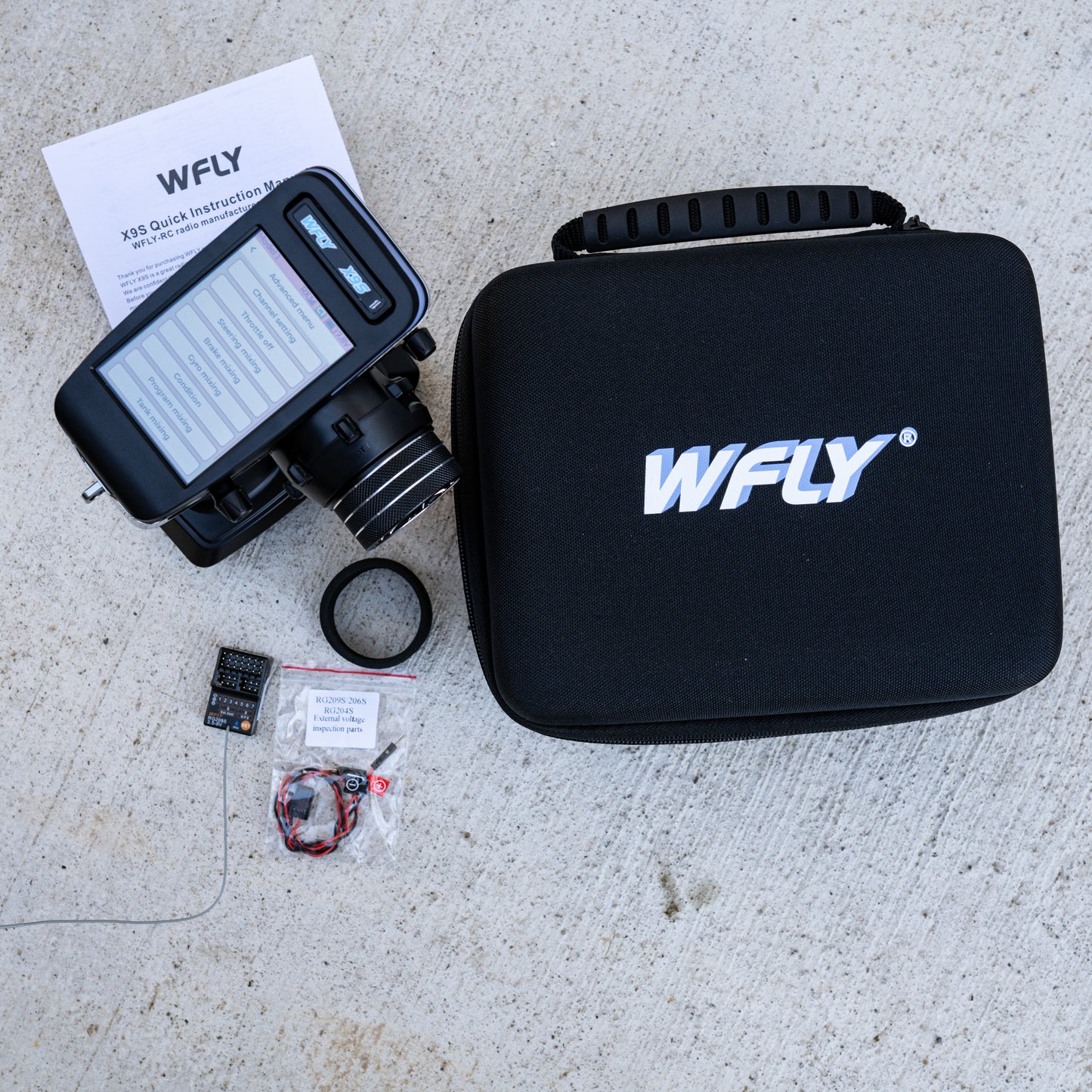 WFLY X9S digital radio system shown with RG209S receiver, wiring, quick instruction manual, and black hard shell carrying case.
