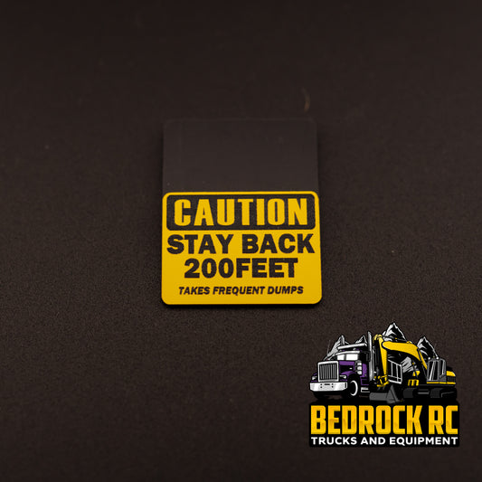 Bedrock Built Caution – Stay Back 200 Feet – Takes Frequent Dumps sign for 1/14 scale RC trucks, laser-etched hard plastic, 31.5 × 23 mm, built in-house by Bedrock RC.